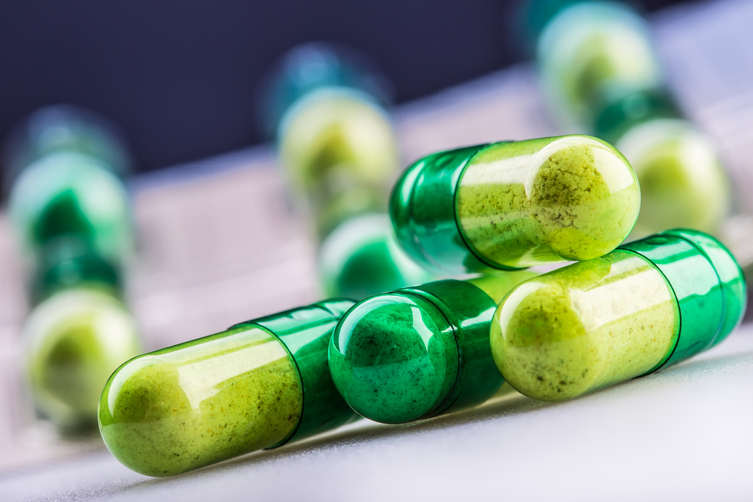 Green,Yellow,Pills,Or,Capsule,Freely,Laid,On,A,White
